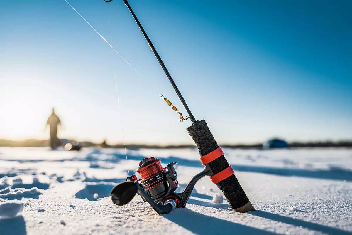 An ice-fishing rod and reel on the ice.