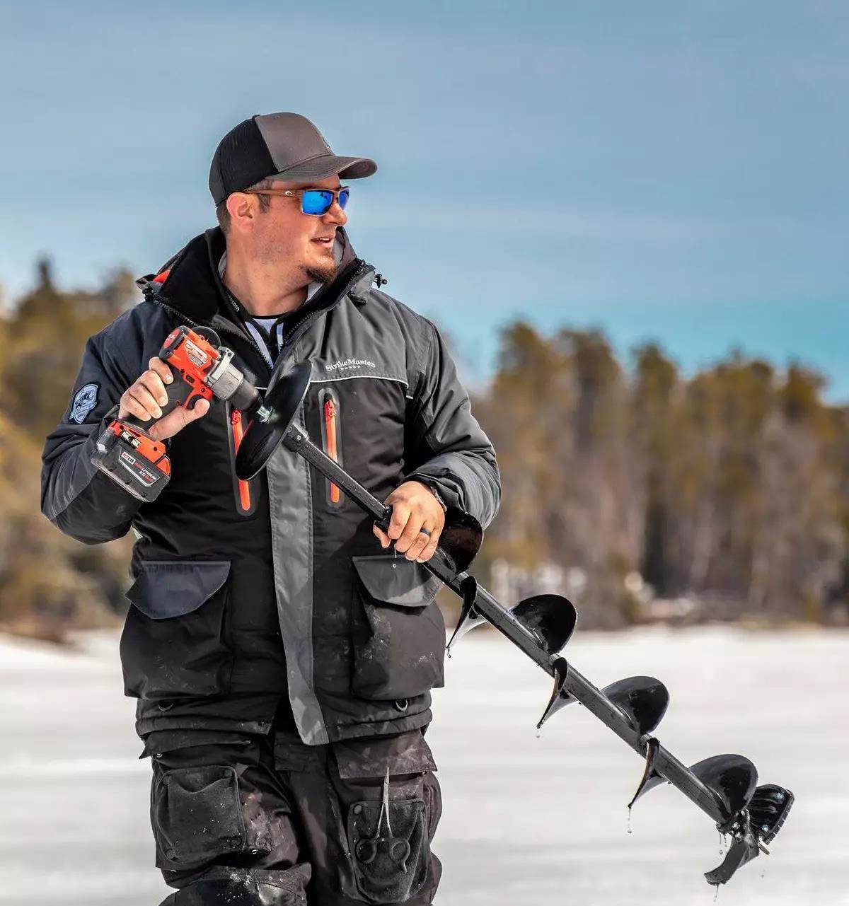 An ice angler holding a drill bit attached to an ice auger bit. 